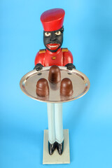 Naklejka premium Statue of a black servant with chocolate cakes on the tray