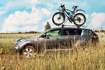 Bicycle transportation - two bikes on the roof of a car against a beautiful sky driving in the...