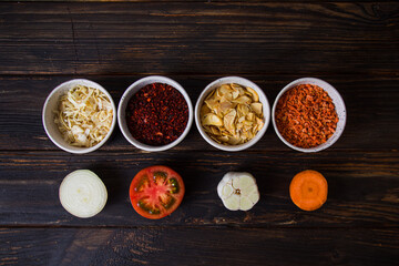 Top view vegetable spices in bowls with their fresh components