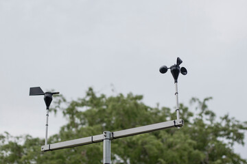 Wind speed and direction meter with sky background.