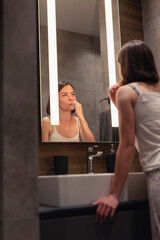 Fototapeta na wymiar Woman brushing teeth in bathroom