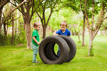 The little boys are interested in the details of a daddy's car