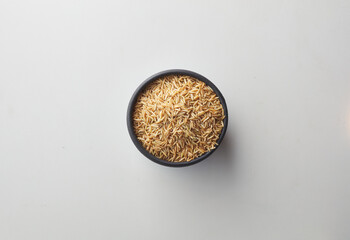 Top view shot of brown rice on white background.
