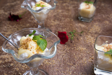 German Snowballs, schneenockerln served in glasses on a wooden table decorated with mint and walnuts