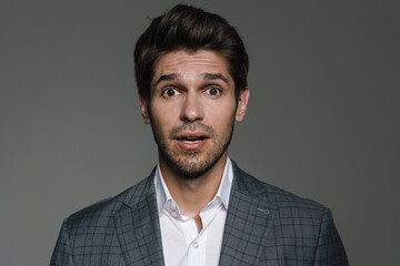 Photo of unshaven excited businessman expressing surprise on camera