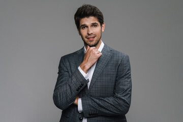 Photo of pleased businessman in jacket posing and smiling at camera