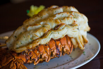 Lobster tail, served with drawn butter and lemon wedges. Maine lobster tail, classic American restaurant favorite. Seasoned with salt and pepper and garnished with Italian parsley.