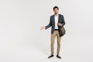 Photo of pleased businessman holding copyspace while posing with bag