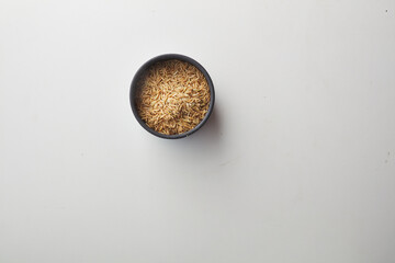 Top view shot of brown rice on white background.