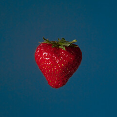 Fruit pop art red strawberry blue color background art side lighting 