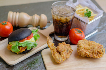 Fastfood & Junkfood concept - hamburger, fries, fries chicken and cola on metalica texture background.