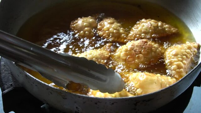 Deep fried Malaysia traditional chicken curry puff in the hot boiling oil.