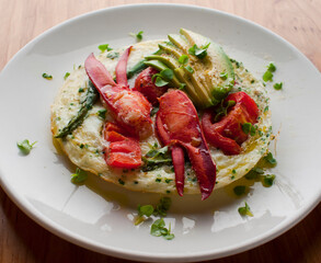 Frittata or omelette lobster avocado. Egg-based Italian dish w/ scrambled eggs, enriched with additional ingredients. classic seafood restaurant brunch/breakfast menu item. Maine lobster frittata. 