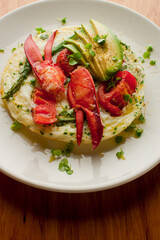 Frittata or omelette lobster avocado. Egg-based Italian dish w/ scrambled eggs, enriched with additional ingredients. classic seafood restaurant brunch/breakfast menu item. Maine lobster frittata. 