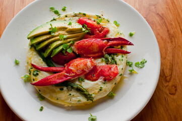 Frittata or omelette lobster avocado. Egg-based Italian dish w/ scrambled eggs, enriched with additional ingredients. classic seafood restaurant brunch/breakfast menu item. Maine lobster frittata. 