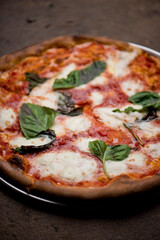 Pizza. Traditional New York City style margarita pizza pie with a thin homemade crispy crust, fresh tomato garlic marinara sauce topped with buffalo mozzarella cheese and fresh basil leaves.