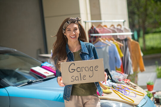 Nice pretty woman holding a sale sign