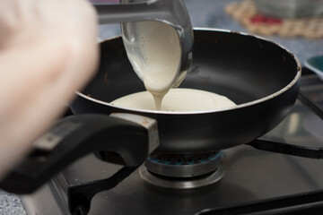 mujer haciendo tortitas una sarten