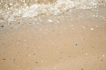 Fototapeta na wymiar Sea sand and waves with sun flare.
