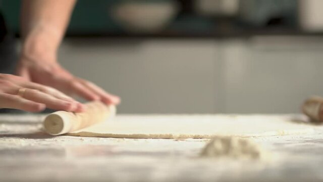 Man cooks pizza. Prepering ingredients for pizza.Roll out the dough with a rolling pin