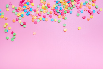 Decorative sugar sprinkles on a pink backdrop.