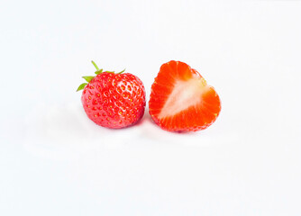 Ripe whole and half strawberries isolated on a white background