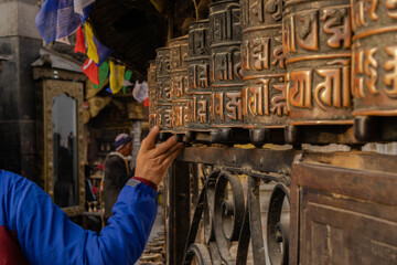Hand touching a praying roll in Kathmandu temple