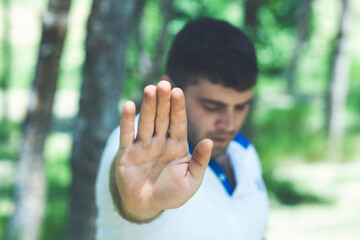 Man with his hands shows stop in the nature