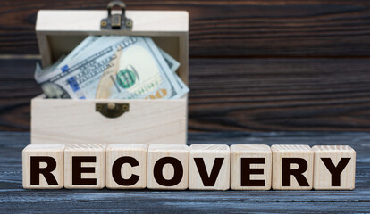 RECOVERY word on cubes with a chest of money against a dark background