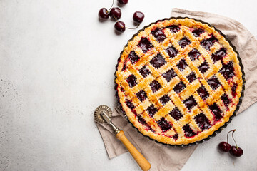 Delicious homemade classic cherry pie with a flaky crust on white background, top view