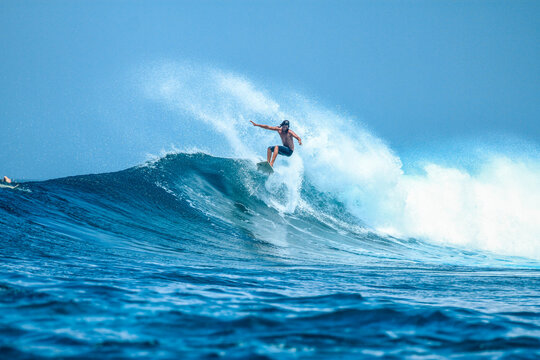 Surfer on perfect blue aquamarine wave, empty line up, perfect for surfing, clean water, Indian Ocean .