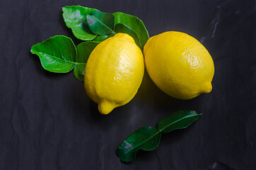 Fresh lemons on dark stone background