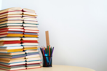 Pile of different books and lot of pencils on table Education concept background Copy space
