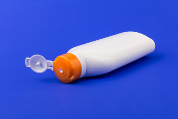 Sunscreen bottle on blue background. Health concepts and skin care