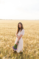 Fototapeta na wymiar Photo of beautiful cute woman posing while walking on wheat field