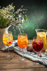 Delicious summer lemonades with ice, strawberry, peach and lime Three glasses with of cocktail on wooden table