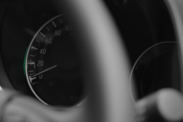 Close up shot of a speedometer in a car with blur foreground steering wheel
