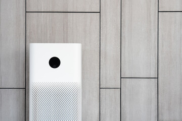 Indoor air purifier with digital monitor screen in living room, show air quality in the room and air pollution levels in the room. with wood laminate wall background