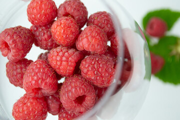 Raspberries lie in a glass