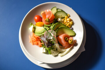 Insalata con salmone, avocado, mais, pomodorini, olive