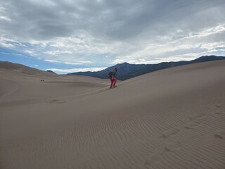 Fototapeta na wymiar Man on a sand dune from a distance