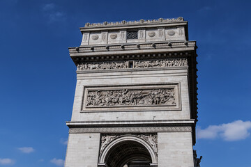 Fototapeta premium Architectural fragment of Arc de Triomphe. Arc de Triomphe de l'Etoile on Charles de Gaulle Place is one of the most famous monuments in Paris. France.