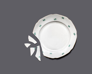 Top view of broken plate isolated on gray.