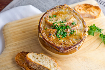French Onion Soup. Classic traditional french restaurant bistro menu item. French onion soup, yellow onions reduced in broth topped with cheese melted and served with homemade baguettes. 