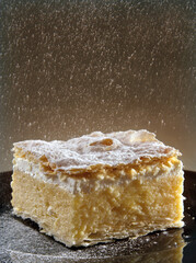 Cream cake.
Powdered sugar falls on the cake. Studio shot.No people
