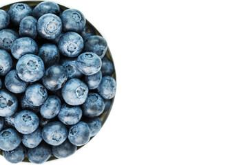 Juicy and ripe Blueberries in a white plate on a white background