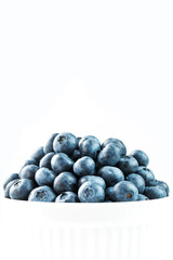 Blueberries are ripe berries in a white Cup on a white background.
