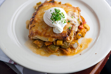 Sunny side up eggs with country potato hash served in a cast iron skillet. muffin with country ham, melted cheese, fried egg & homemade hollandaise sauce. Classic French or American cuisine favorite.