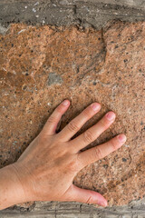 the woman leaned her hand against the stone wall.