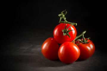 Red mini tomatoes isolated on dark background.Studio shot